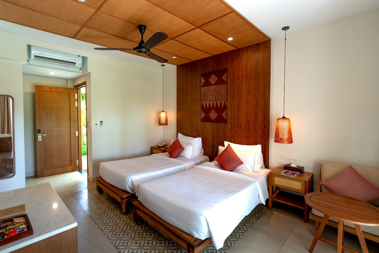 room-03 Spacious hotel room featuring twin beds, wooden decor, and modern amenities.