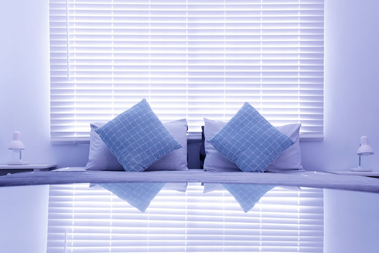 Stylish and modern bedroom with blue cushions and blinds, reflecting a calm and cozy atmosphere.